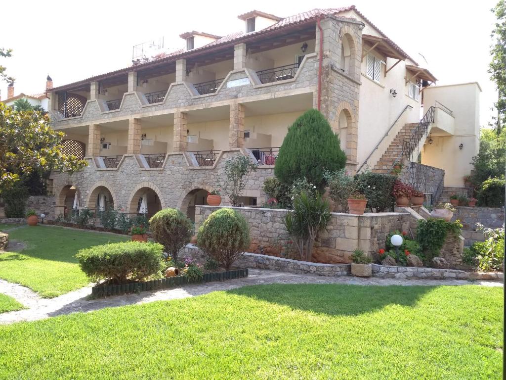 a large house with a garden in front of it at Maini Studios in Stoupa
