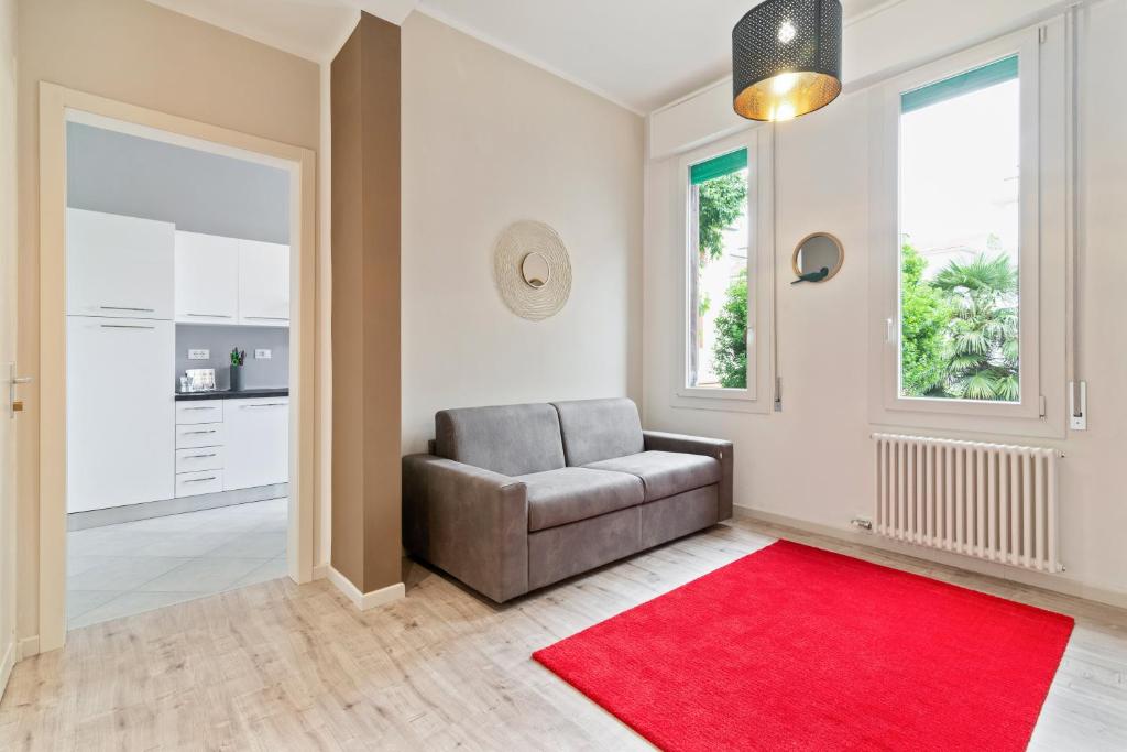 ein Wohnzimmer mit einem Sofa und einem roten Teppich in der Unterkunft Prato della Valle Central Apartment in Padua