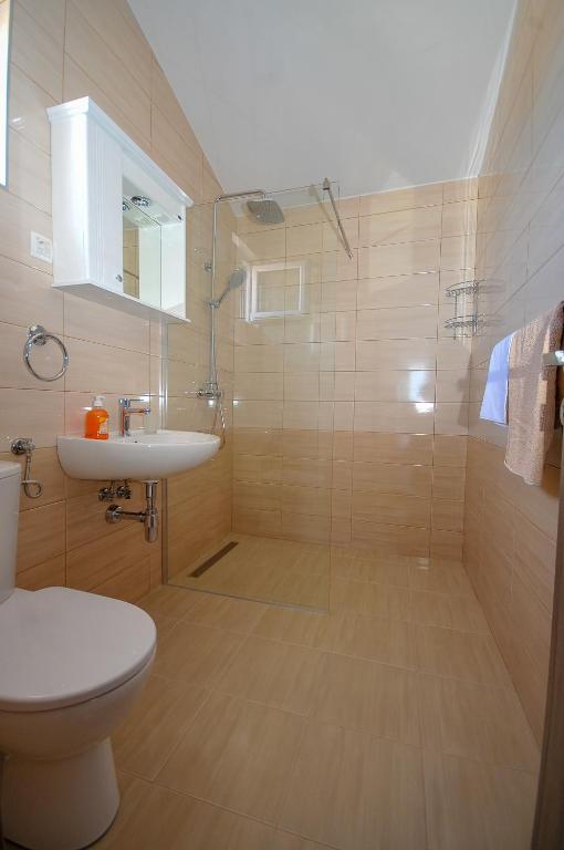 ein Badezimmer mit Dusche, Toilette und Waschbecken in der Unterkunft Apartmani Vitic in Bar