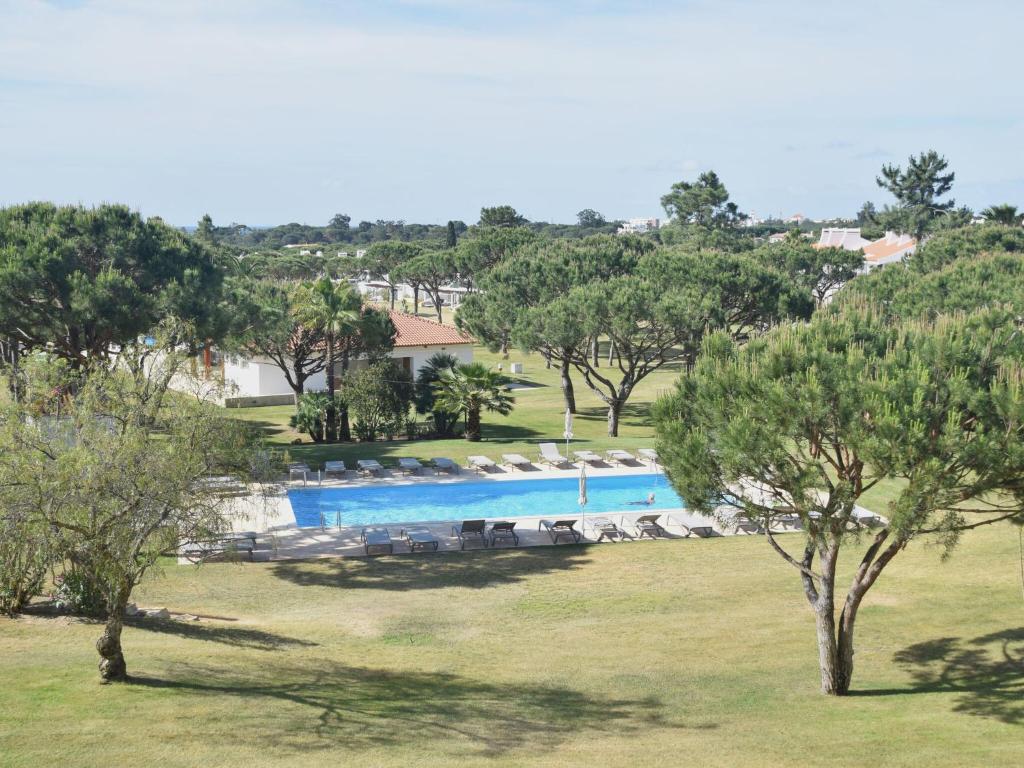 ヴィラモウラにあるSpacious Apartment in Quarteira with Swimming Poolの畑の木々が植わるスイミングプールの景色