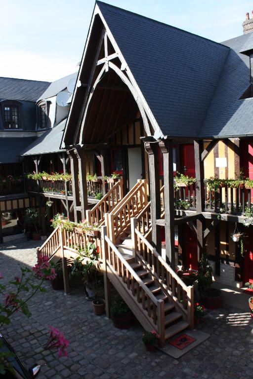 - un petit bâtiment avec un escalier en bois devant dans l'établissement Hotel La Diligence, à Honfleur
