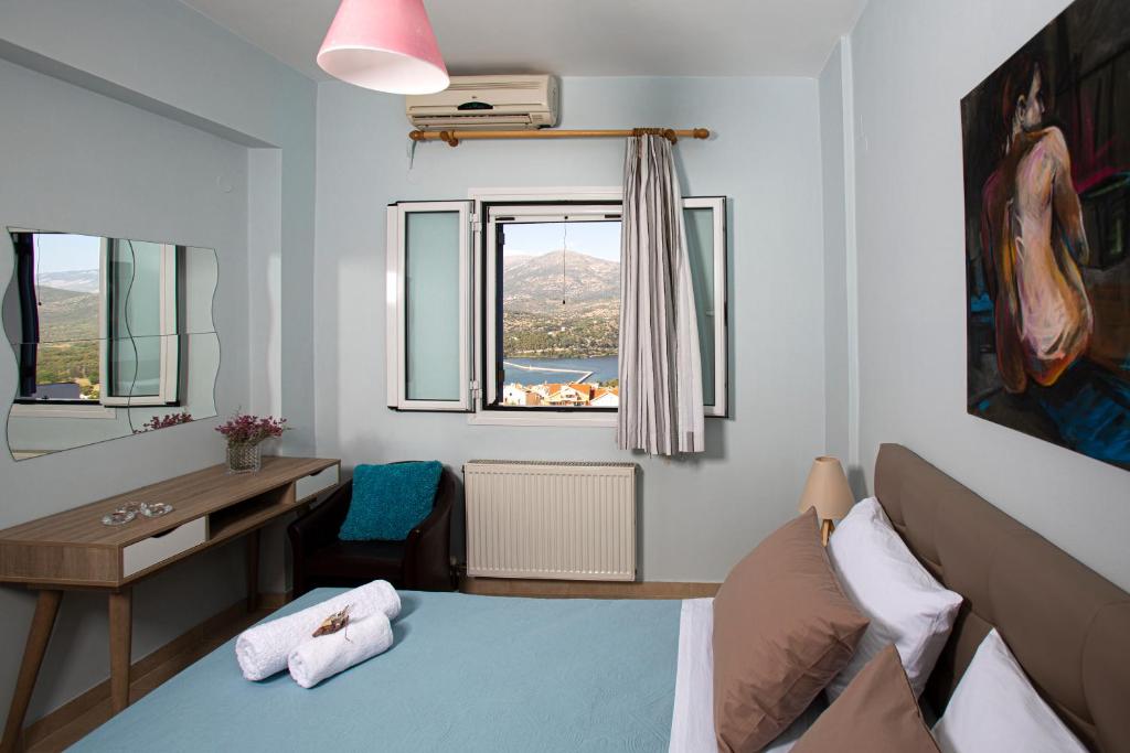 sypialnia z łóżkiem, biurkiem i oknem w obiekcie Antigone Apartments Argostoli (Spilia) 2 w mieście Argostoli