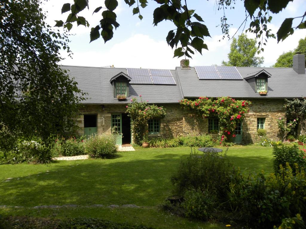 une maison avec des panneaux solaires sur le toit dans l'établissement Le Lavoir de Julia, à Bourgvallées