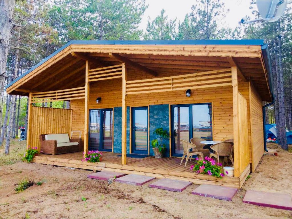 a small wooden house with a table and chairs at Gradina Forest Villas in Sozopol