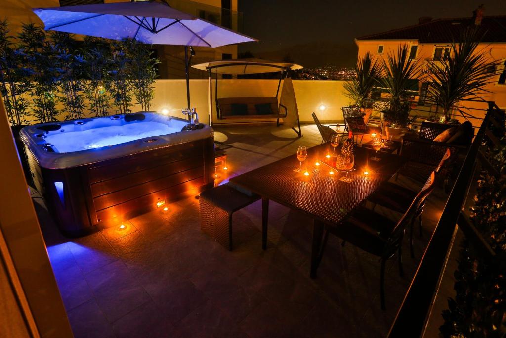 een patio met een hot tub en een tafel met verlichting bij Luxury Urban Villa Apartments With Jacuzzi in Split