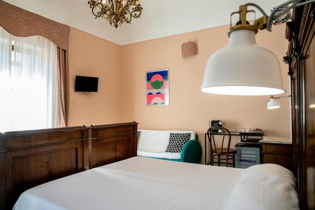 a bedroom with a bed and a chandelier at Dimora La Torre Room in Favignana