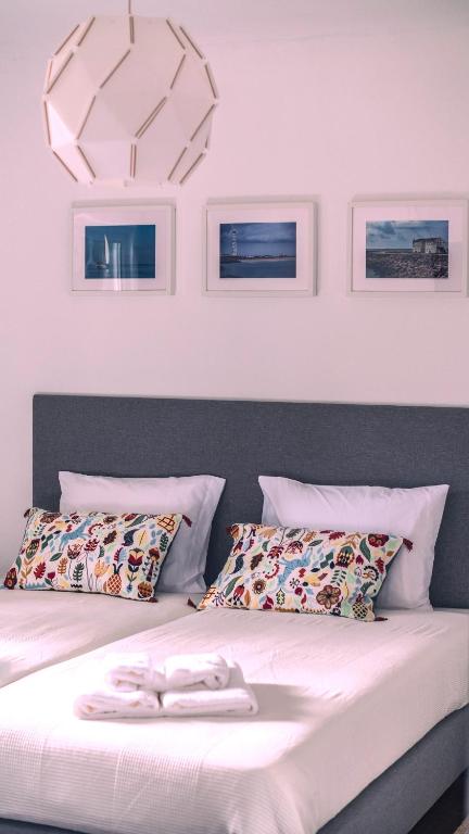 a bed with two white towels on top of it at Pine House - Faro Airport, Beach and City Center in Faro