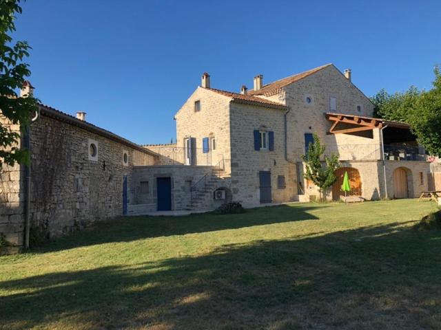 a large stone building with a grassy yard at DOMAINE MARY'S in Barjac