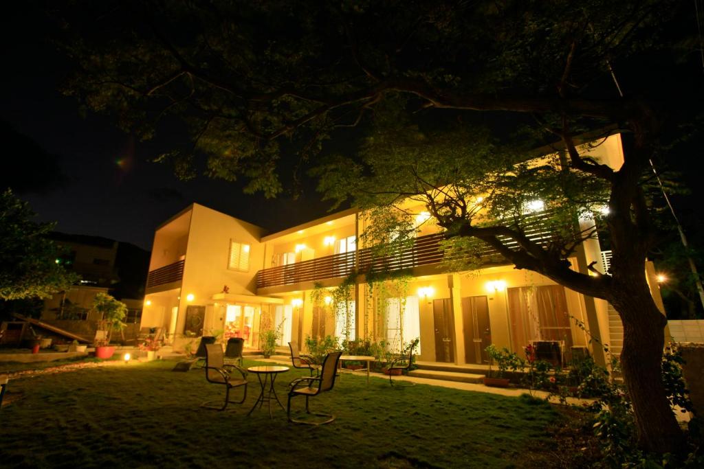 a building with a table and chairs at night at Cha Villa in Zamami