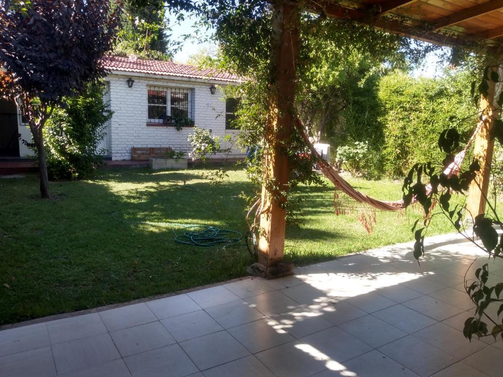 a backyard with a wooden pergola and a house at Disfruta como local in Mendoza