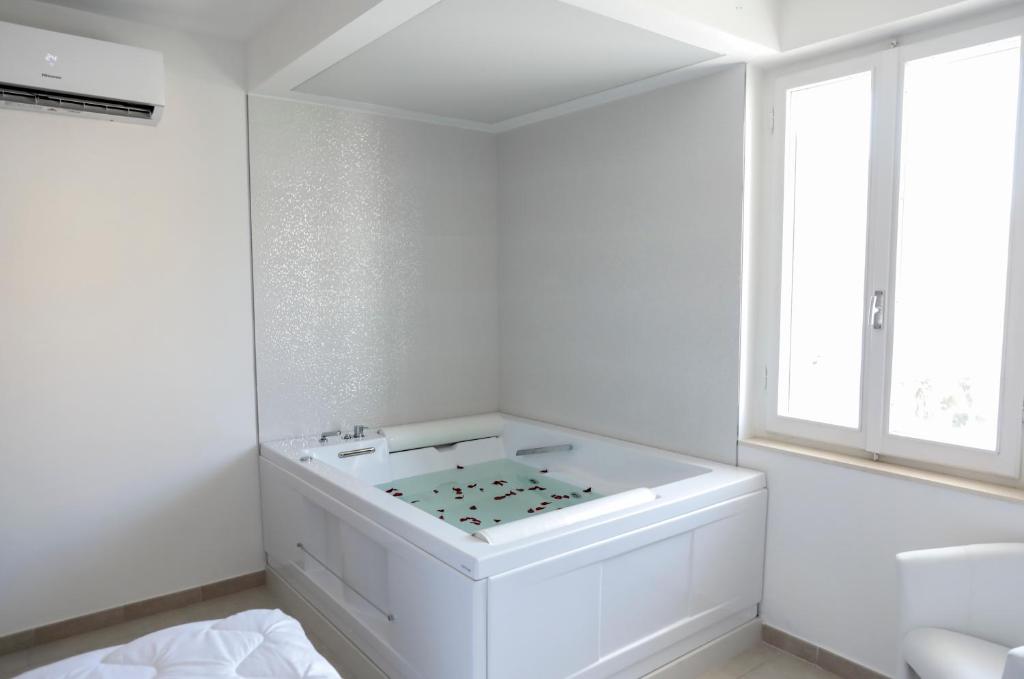 a white bathroom with a sink and a window at R & D in Alghero