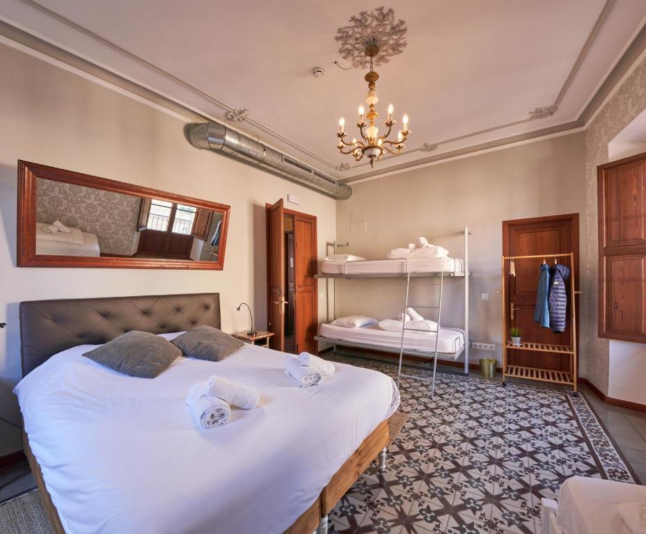 a bedroom with a large bed and a chandelier at Hostel Sóller in Sóller