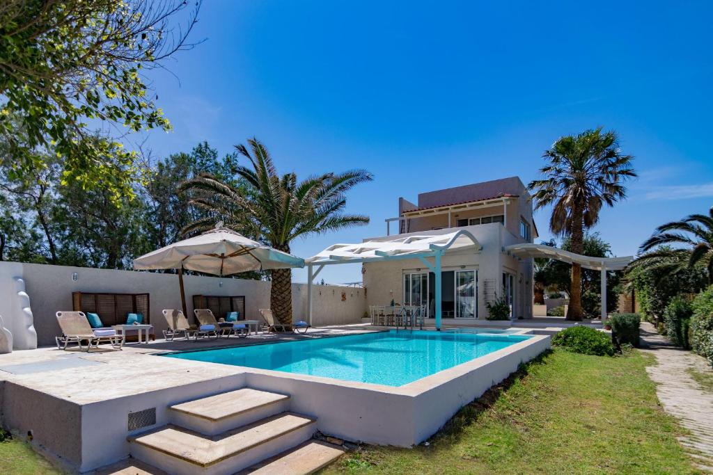 een villa met een zwembad en een huis bij Almirikia in Pigianos Kampos