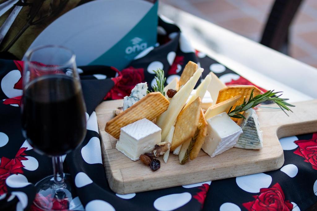 a plate of cheese and crackers and a glass of wine at Ona Alanda Club Marbella in Marbella