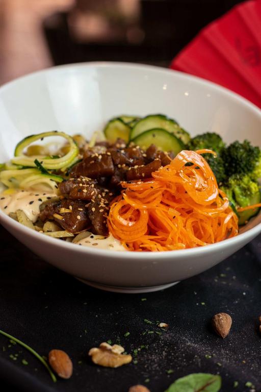a white bowl of food with noodles and vegetables at Ona Alanda Club Marbella in Marbella