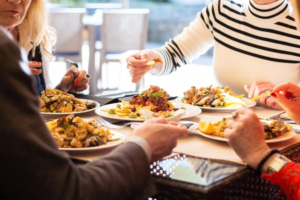 a group of people sitting around a table eating food at Ona Alanda Club Marbella in Marbella