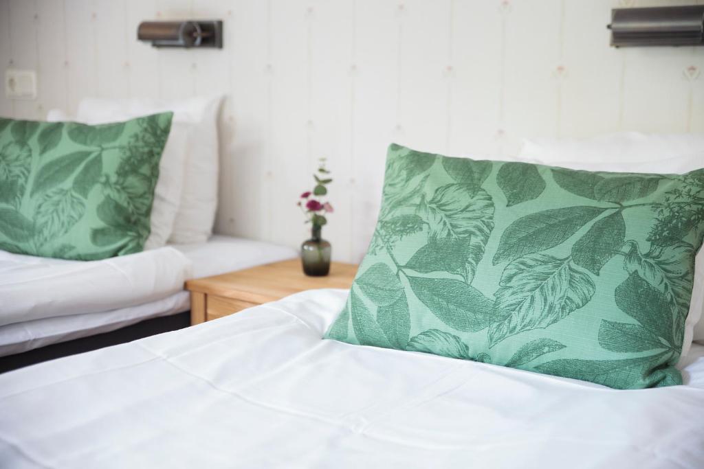 a bedroom with a bed with green pillows and a couch at STF Hotel Zinkensdamm in Stockholm