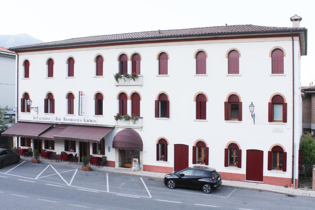 a black car parked in front of a white building at Al Cavallino in Follina