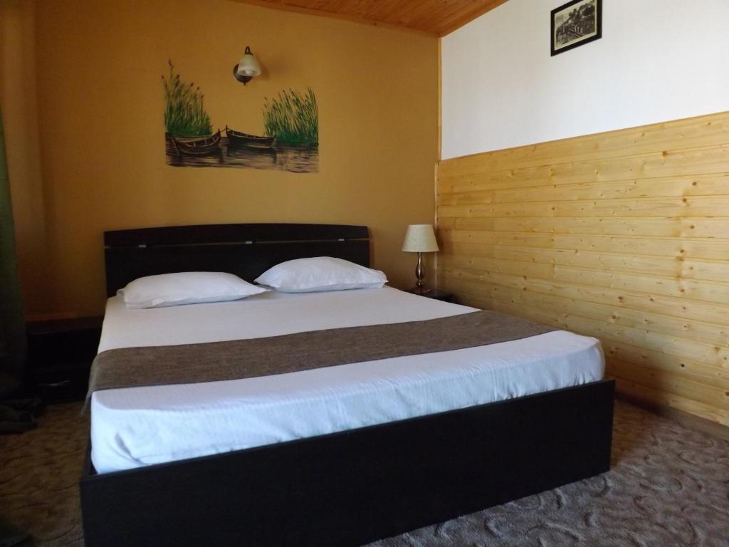una camera da letto con un grande letto con lenzuola bianche di Casa Mister a Sulina