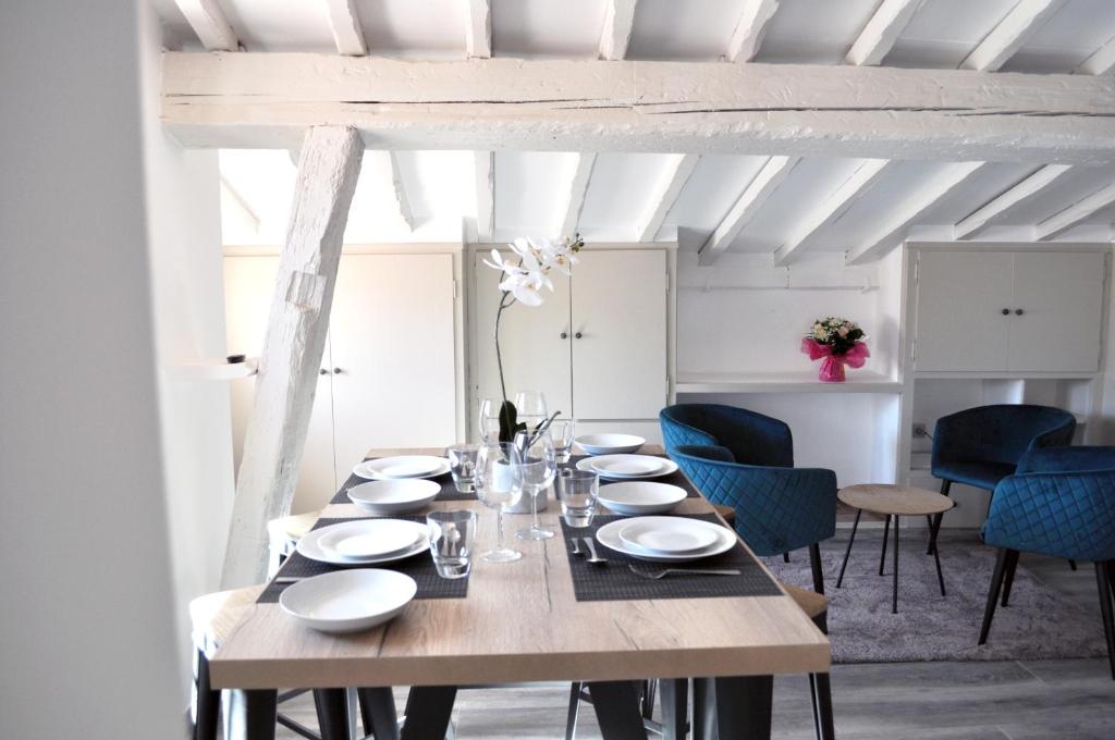 a dining room with a wooden table and blue chairs at Ibanova Appartements in Collioure
