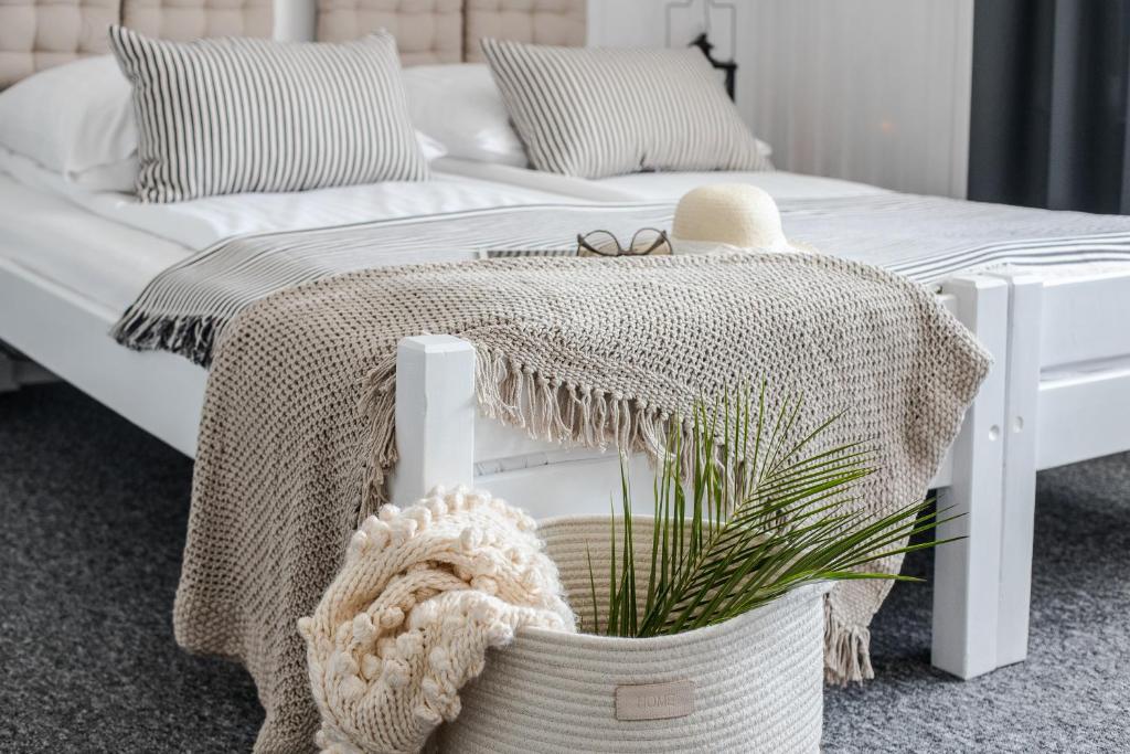sypialnia z białym łóżkiem i koszem z rośliną w obiekcie Willa Pod Termą - obok Termy Bania w mieście Białka Tatrzanska