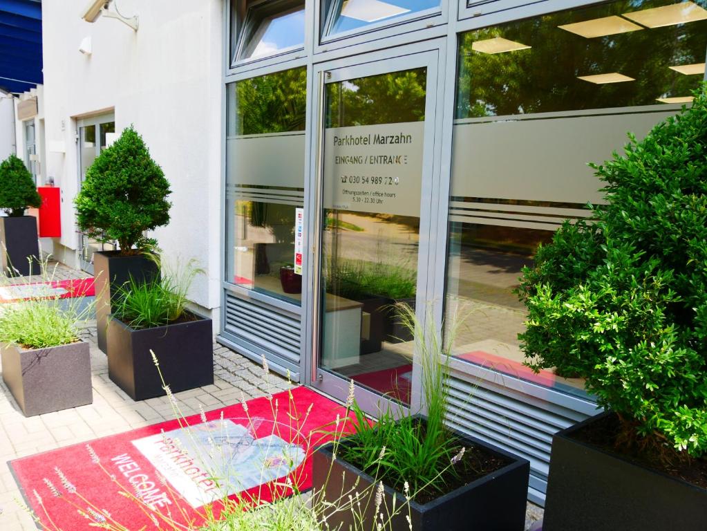 un front de magasin avec des plantes en pot en dehors de celui-ci dans l'établissement Parkhotel Marzahn, à Berlin