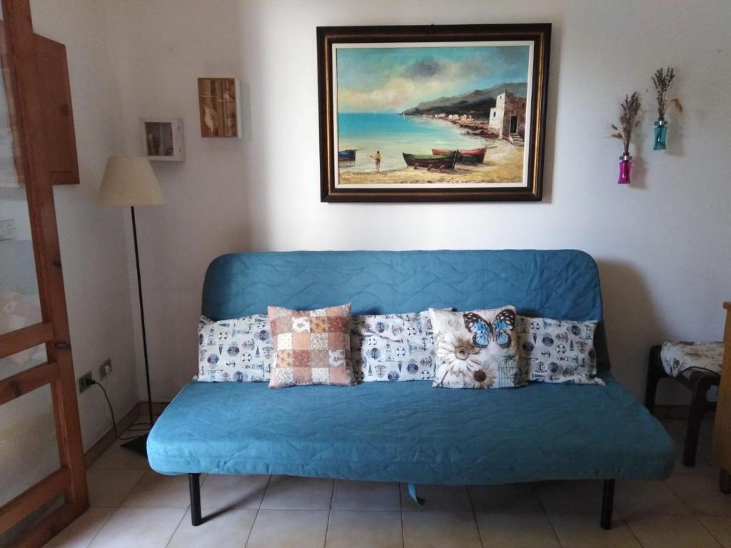 un divano blu in soggiorno con un dipinto di Casa Poesia a Torre dell'Orso