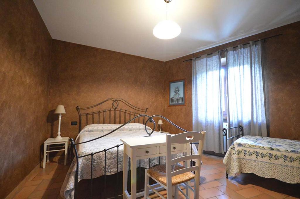 1 dormitorio con cama, mesa y ventana en ristorantino il Sovrano BeB, en SantʼAnatolia di Narco