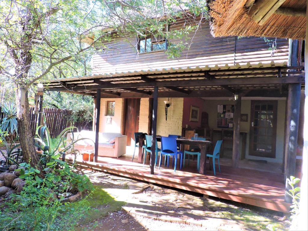 a wooden deck with a table and chairs on it at Kruger Inn Backpackers in Marloth Park