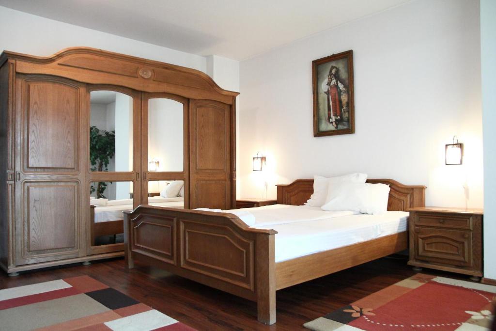 クルジュ・ナポカにあるMellis 1のベッドルーム(大型木製ベッド1台、鏡付)