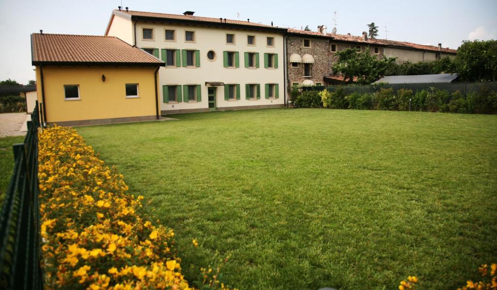 un gran patio con una casa y flores amarillas en Ca' Vittori en Valeggio sul Mincio