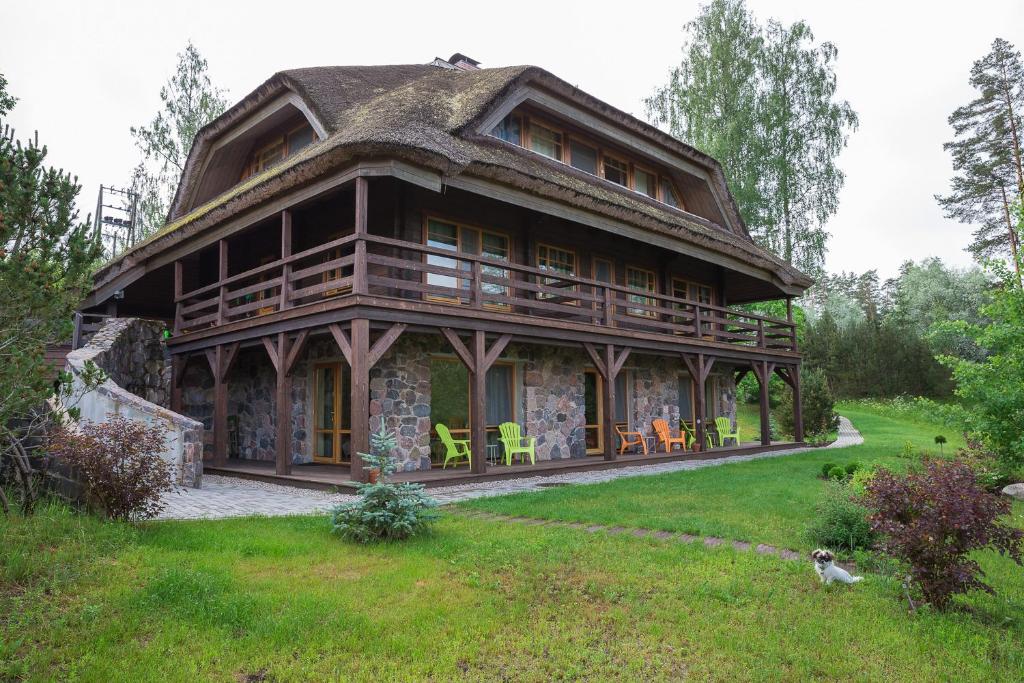 Cabaña de madera grande con techo de paja en Dzeņi en Amatciems