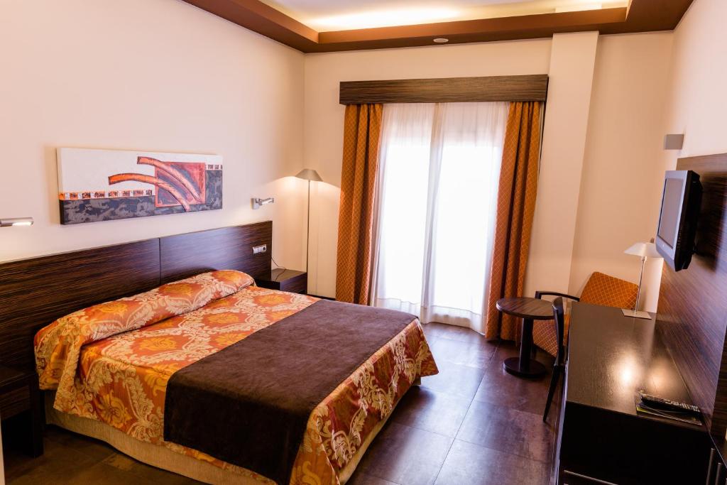 Cama o camas de una habitación en Hospedium Hotel Los Periquitos