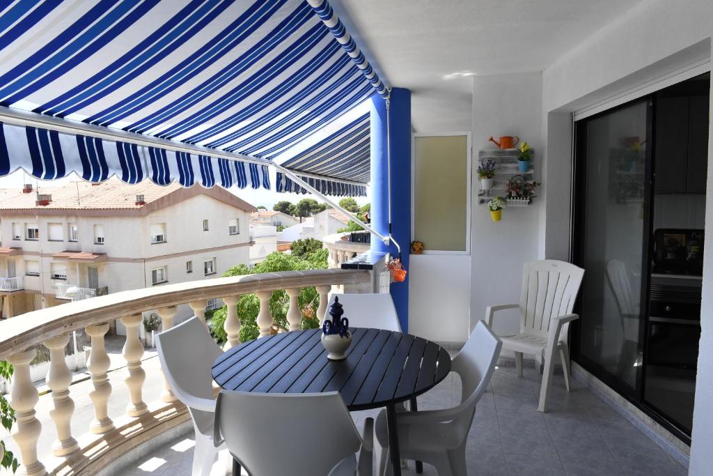 a balcony with a blue and white a table and chairs at Appartement exceptionnel confortable bord de mer in Sant Carles de la Ràpita