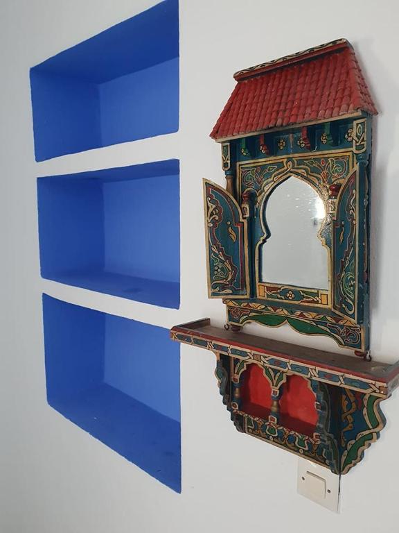 a small mirror sitting on top of a shelf at Hotel Ouarzazate in Chefchaouene