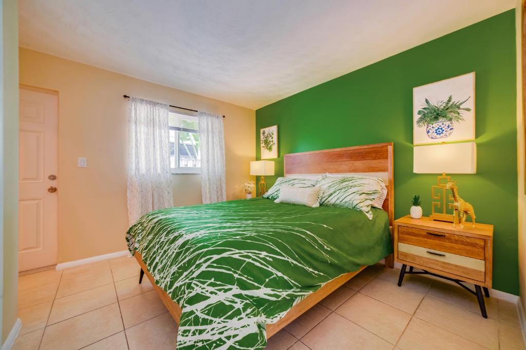 Dormitorio verde con cama y mesita de noche en Beautiful Old Apartment with Beach Gear en Fort Lauderdale