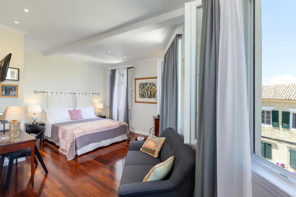 una camera con letto, divano e finestra di Dousmani Corfu Old Town Studio Suite a Città di Corfù