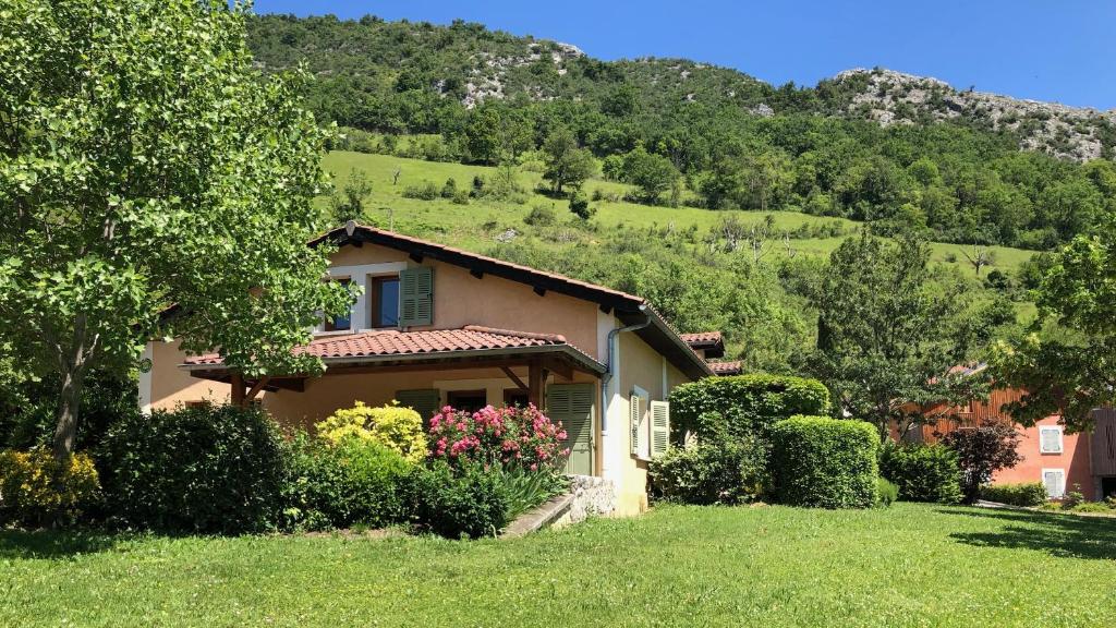 una casa en un campo con una montaña en el fondo en Gites le Paradis - Superbe vue sur le Vercors Dominant le village en Pont-en-Royans