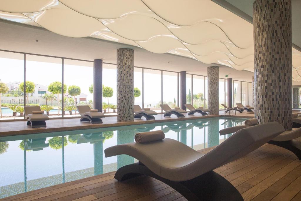 a pool in a hotel with chairs and a swimming pool at ON'LIVE HOTEL in Çeşme