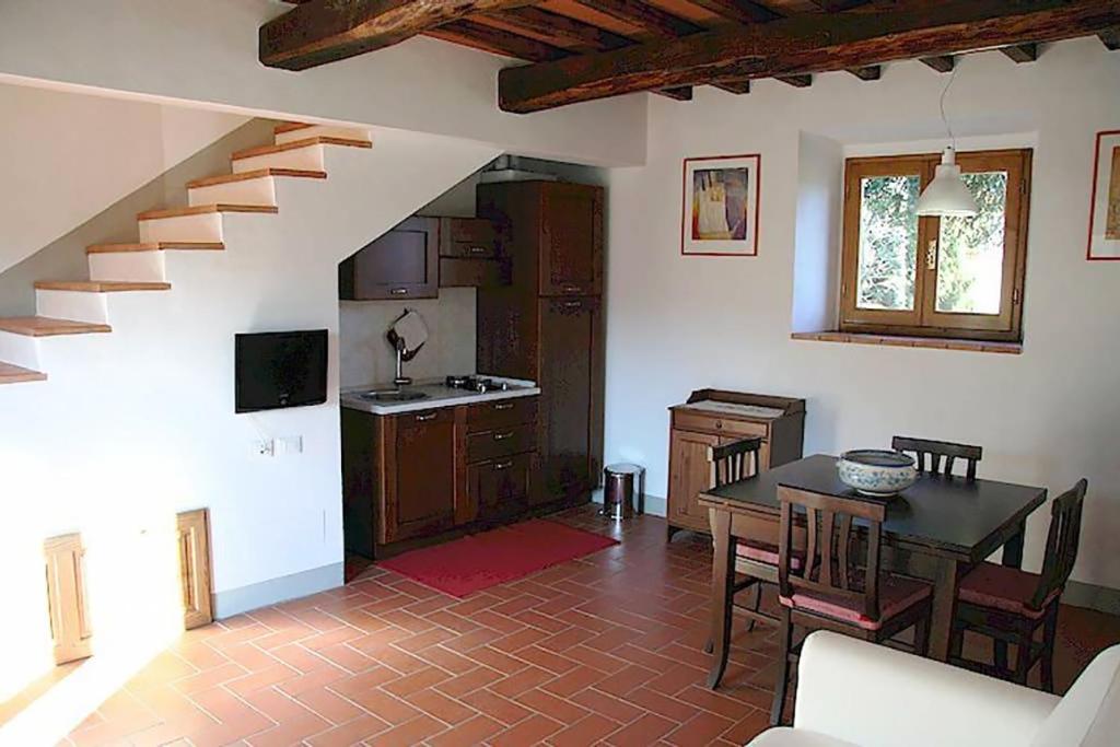 cocina y comedor con mesa y escalera en Montebeni Apartments, en Greve in Chianti