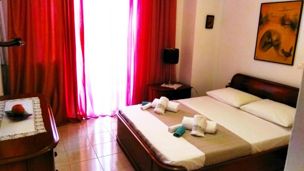 deux lits dans une chambre avec des rideaux rouges dans l'établissement Maria 's home, à Héraklion