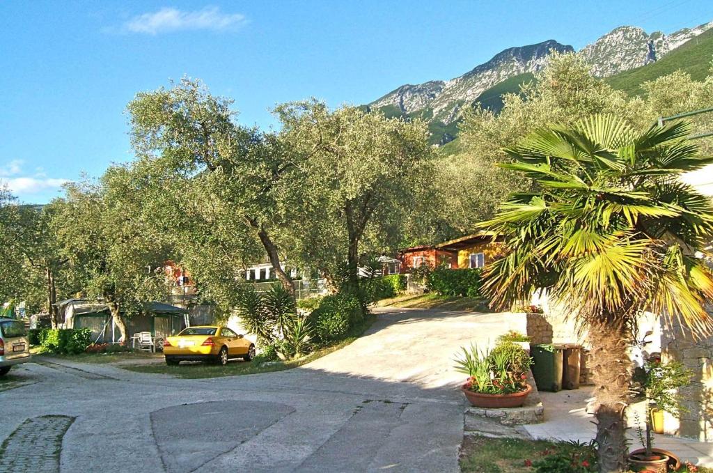 een gele auto geparkeerd op een straat met bergen op de achtergrond bij Aquacamp in Brenzone sul Garda