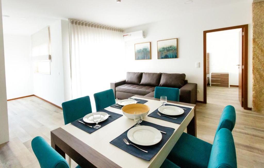 uma sala de jantar com uma mesa e cadeiras azuis em Apartamentos Castelo na Póvoa do Varzim