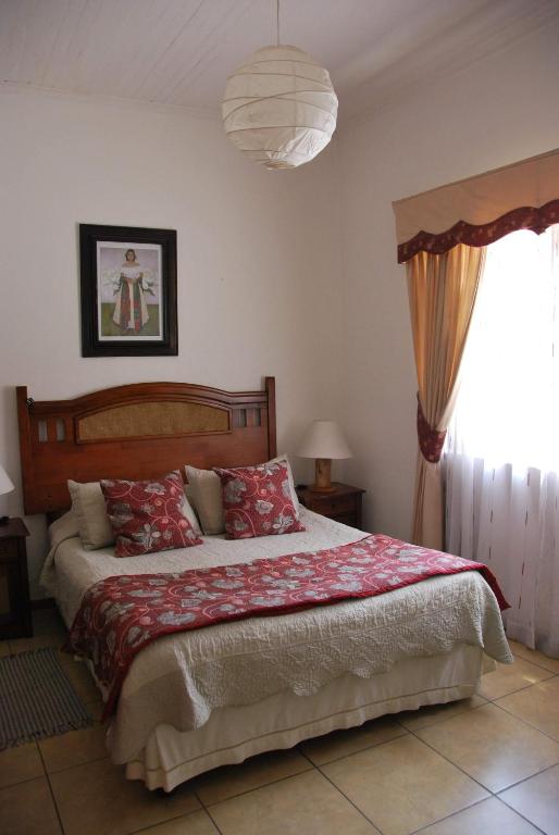 Un dormitorio con una cama grande con una manta roja. en Hotel Empresarial, en Los Ángeles