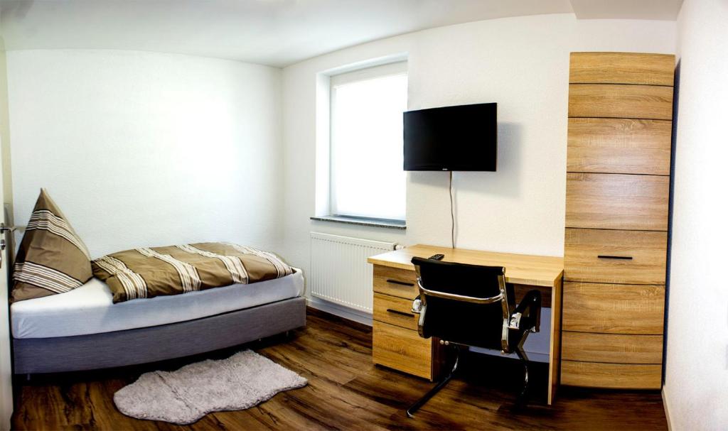 een slaapkamer met een bed, een bureau en een raam bij Pension zum Hecht in Schemmerberg