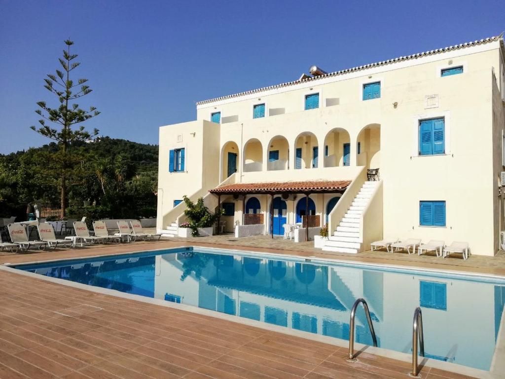 una casa con piscina frente a un edificio en Lianos Hotel Apartments, en Spetses