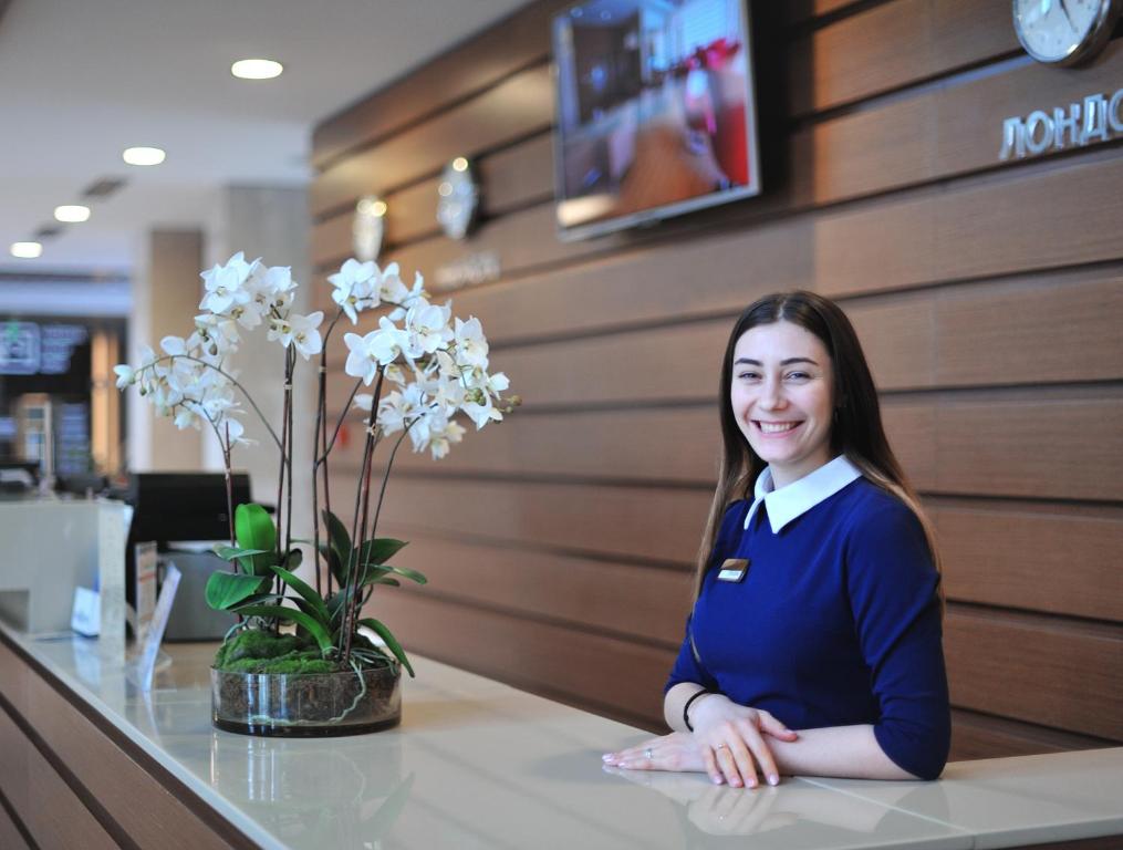 a woman sitting at a counter in a restaurant at Arfa Park-Hotel in Adler