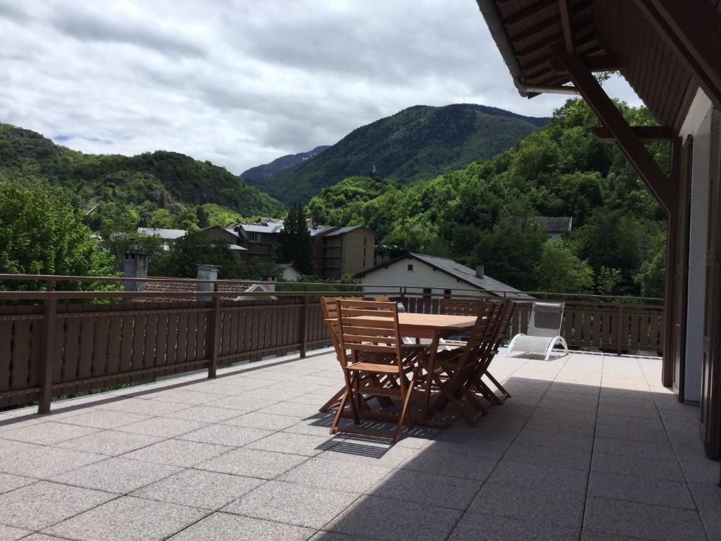 a table and chairs on a balcony with mountains at Au chalet des quatre saisons in Ax-les-Thermes