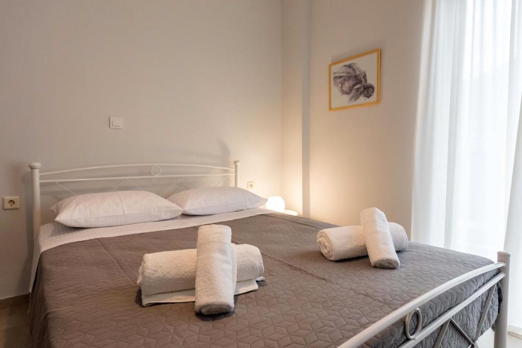 sypialnia z łóżkiem z ręcznikami w obiekcie Avra Apartment w Kalamácie