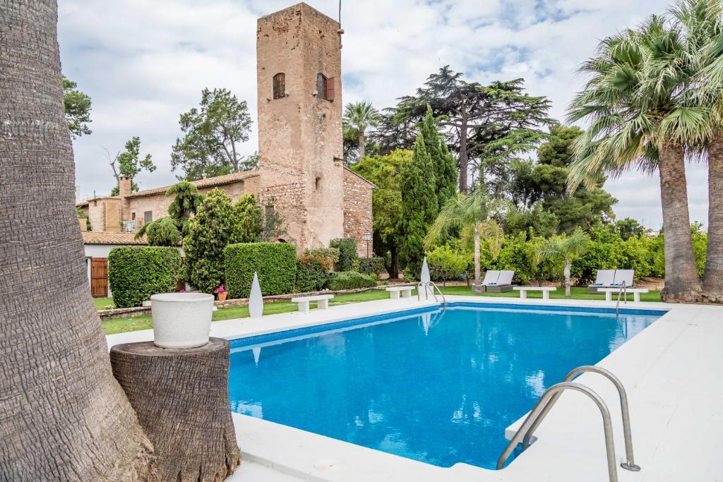 a villa with a swimming pool and a tower at Alquería Calatrava B&B in Burriana